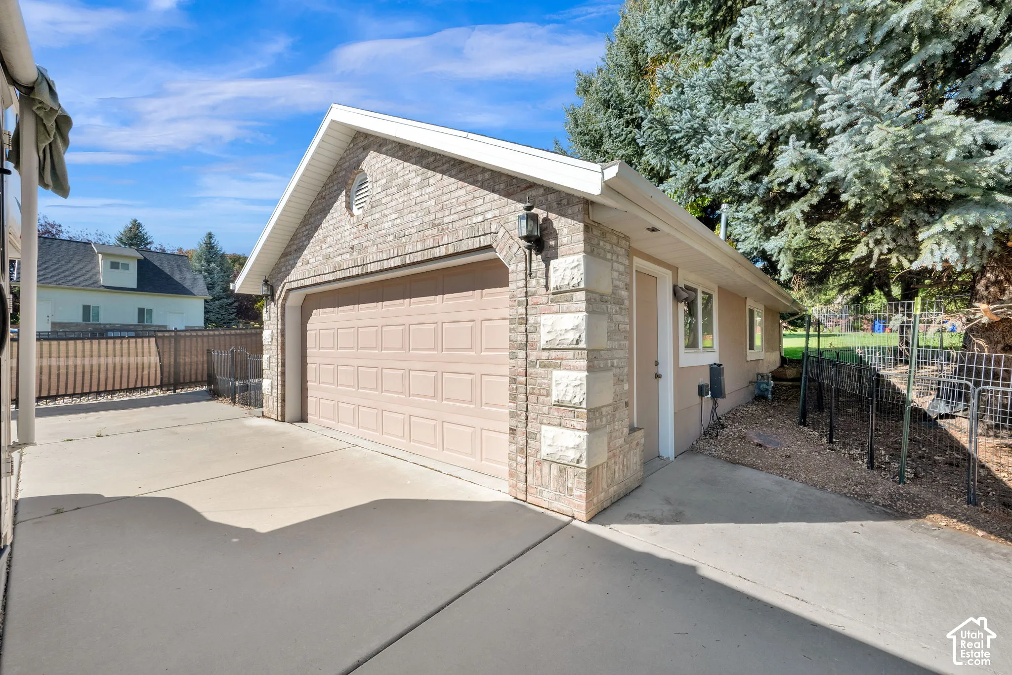 Attached two-car garage with a panel door, brick and stone exterior, and a secondary entry door