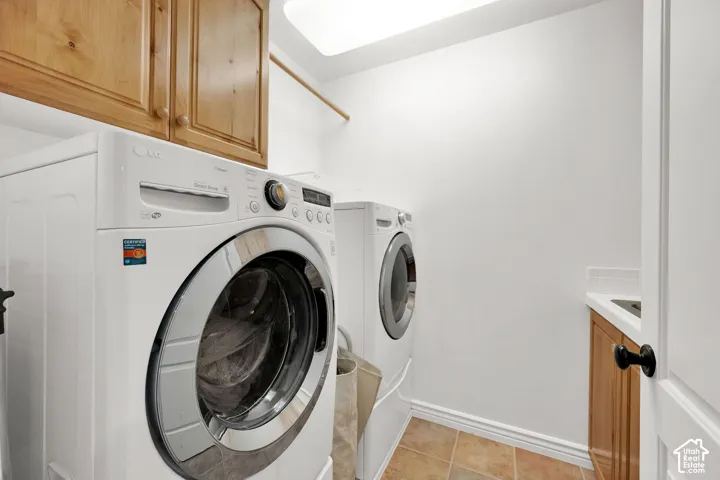 Laundry area featuring wood cabinetry, a built-in sink with countertop, and tile flooring