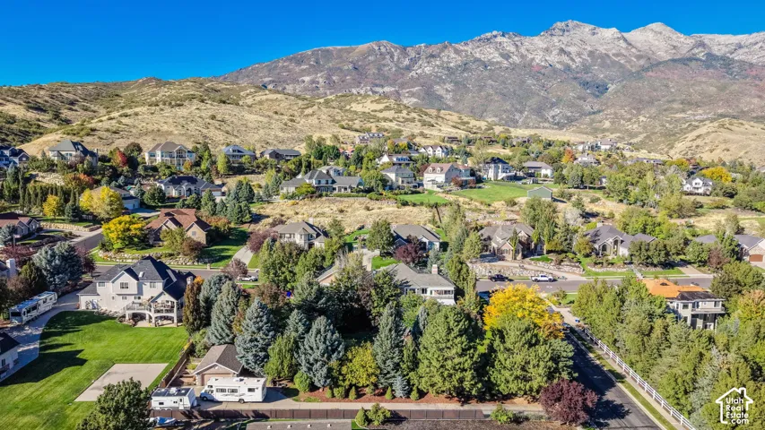 Expansive neighborhood with diverse architectural styles, mature landscaping, and mountainous terrain