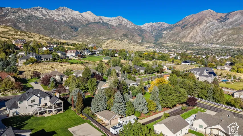 Mountain backdrop, residential area, mature trees, landscaped grounds, varied architectural styles