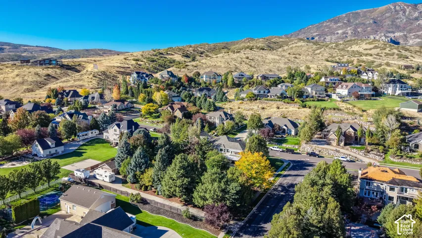 Expansive residential area featuring established homes, mature trees, and mountainous terrain