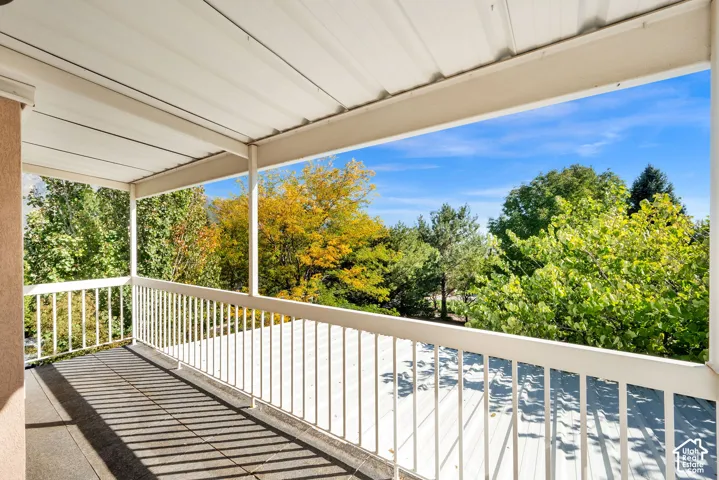 Covered outdoor patio with a metal railing and a tiled floor