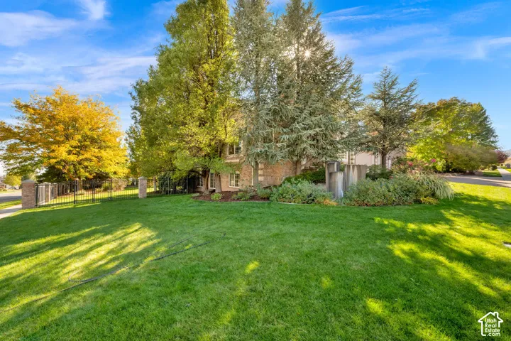 Expansive front lawn with mature trees and a stone-clad exterior