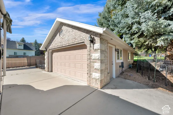 Attached two-car garage with a panel door, brick and stone exterior, and a secondary entry door