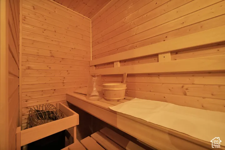 Wood-paneled sauna featuring built-in benches and a sauna heater