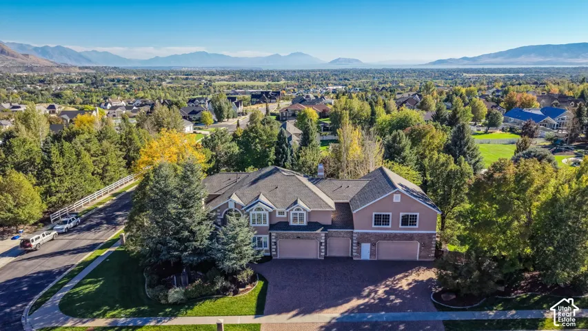 Two-story residence featuring a multi-car garage, dormer windows, and a brick-finish facade