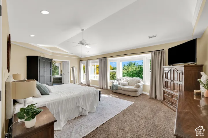 Tray ceiling with recessed lighting and a ceiling fan, bay window with multiple panes, double doors, and wall-to-wall carpeting