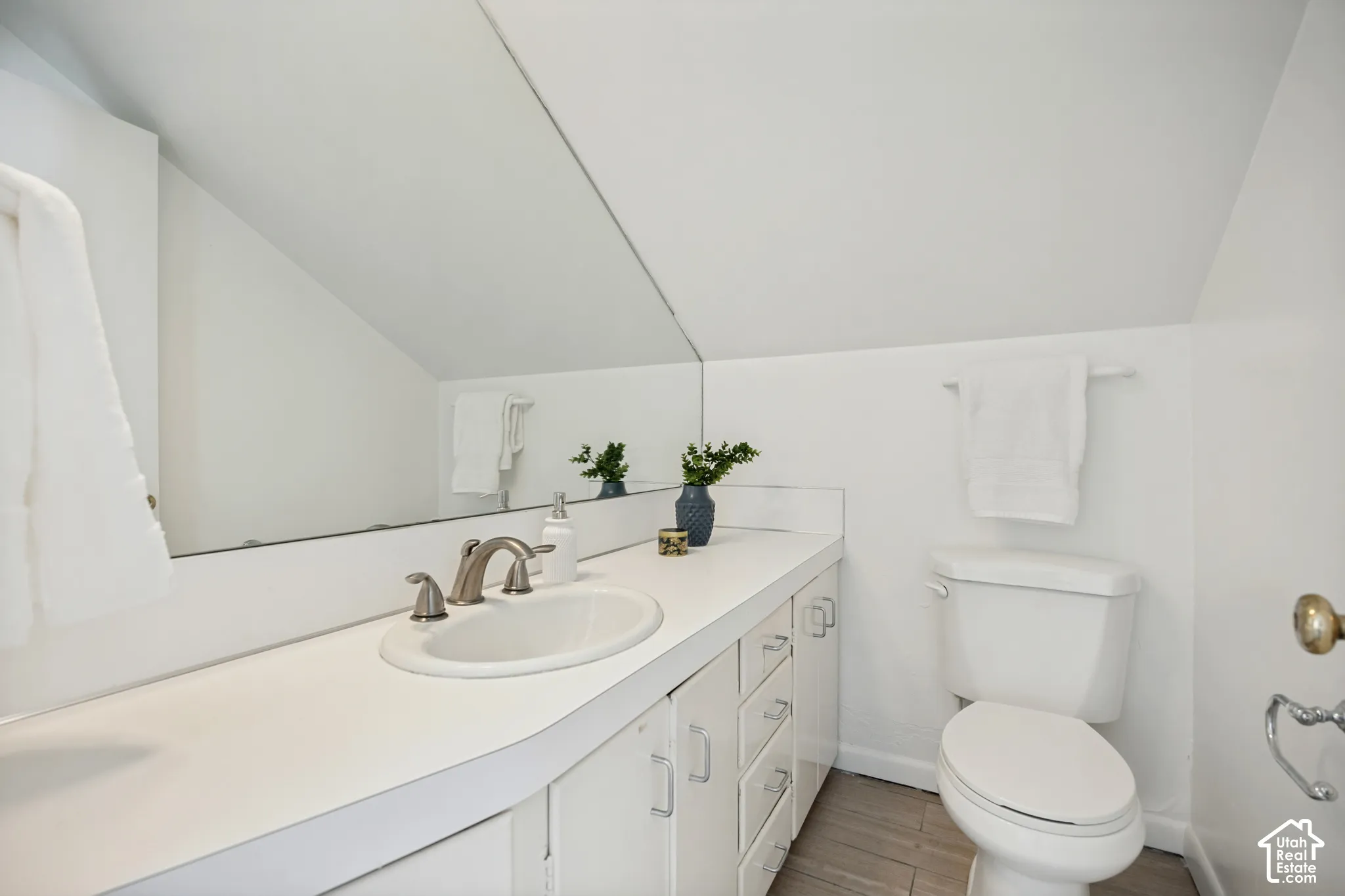 Integrated vanity with an oval sink, brushed nickel faucet, and white countertop