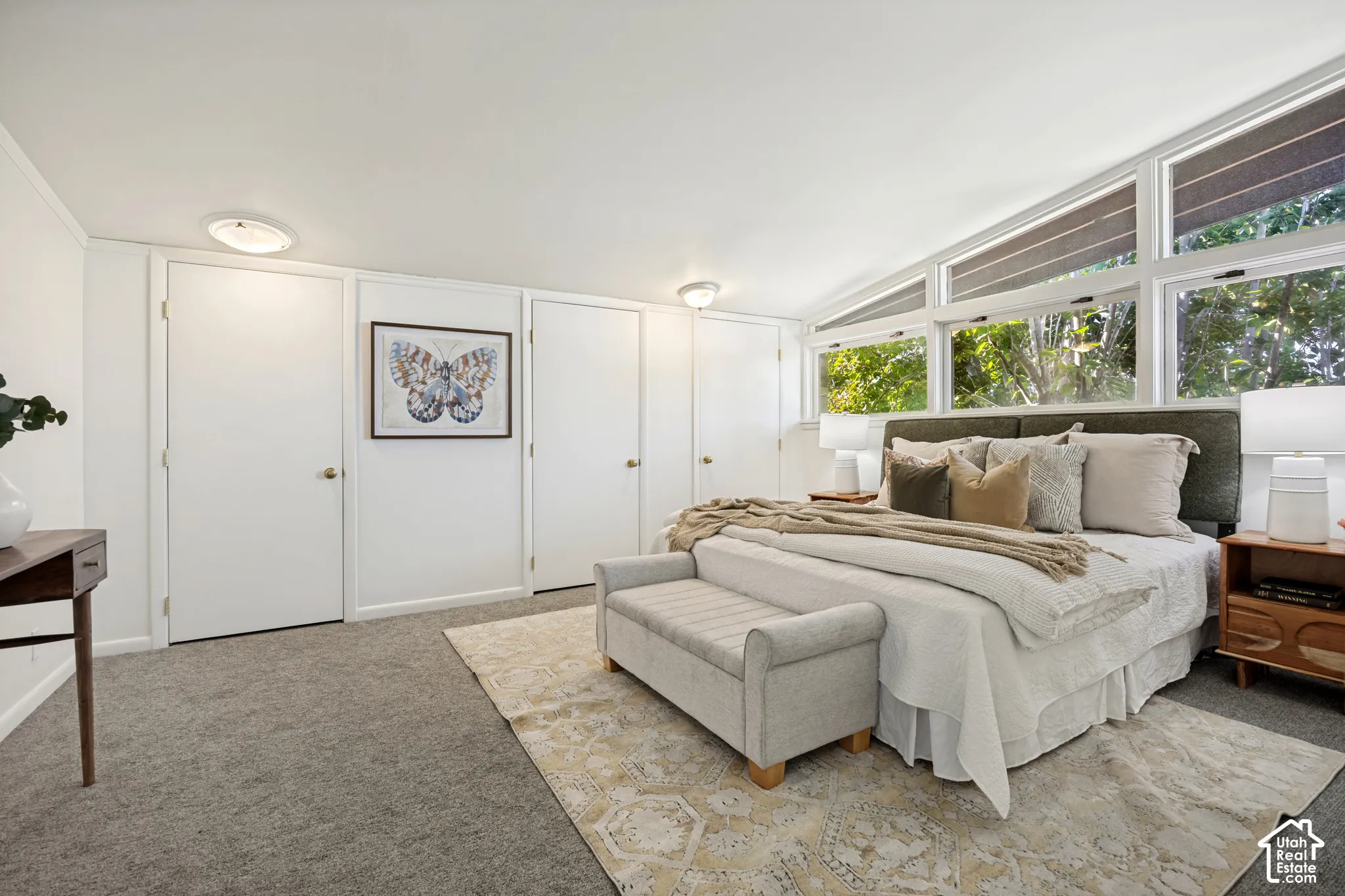 Vaulted ceiling with transom windows, white interior doors, and carpeted flooring