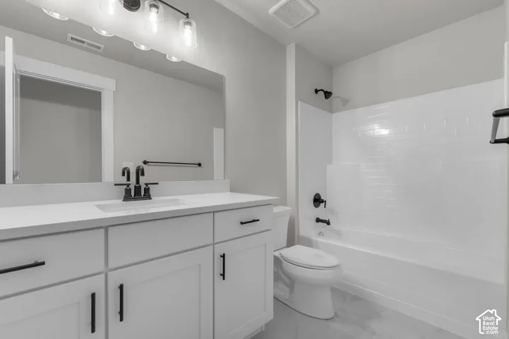 White vanity with a solid surface countertop and integrated rectangular sink