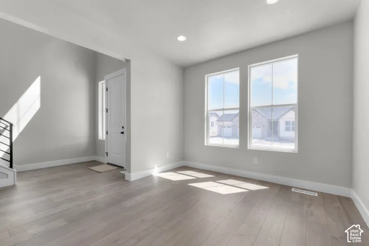 Wood-finish flooring, recessed lighting, and white trim
