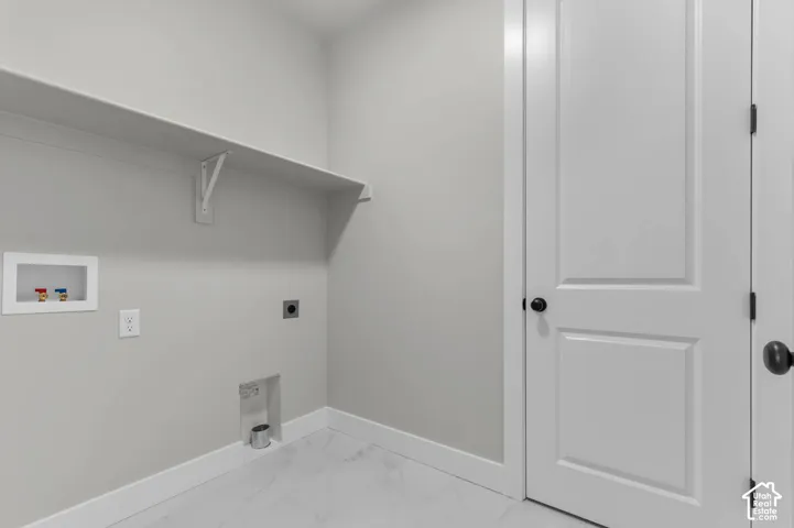 Laundry area featuring white wood-finish shelving and a white paneled door