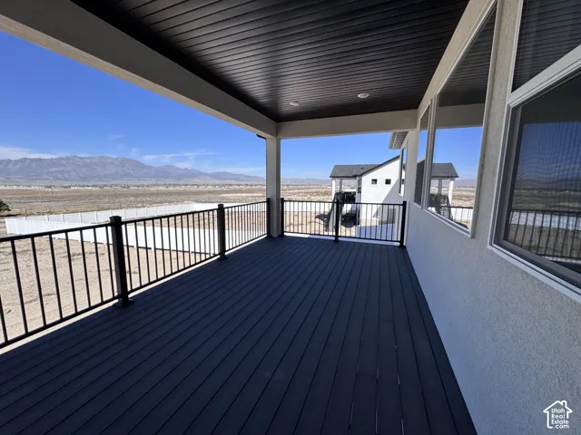 Covered outdoor deck with dark composite decking and black metal railing