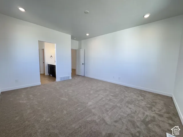 Recessed lighting, light-toned carpeting, white walls, white trim, and a dark wood-finish vanity