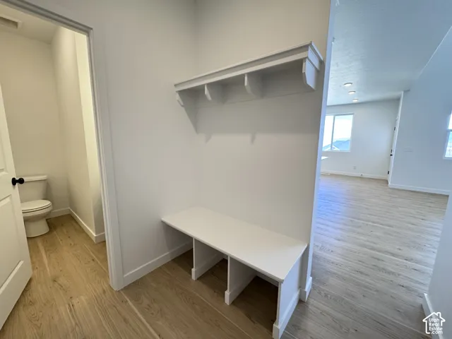 Built-in bench and shelving, wood-finish flooring throughout, recessed lighting, and white trim