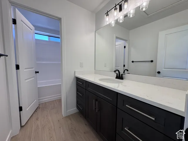 Dark wood-finish vanity with quartz countertop, undermount sink, and matte black faucet