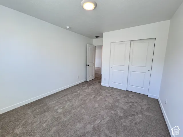 Neutral-toned carpeting, white walls, and a ceiling-mounted light fixture