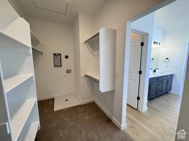 Walk-in closet with built-in shelving, hanging rods, and a laundry hookup