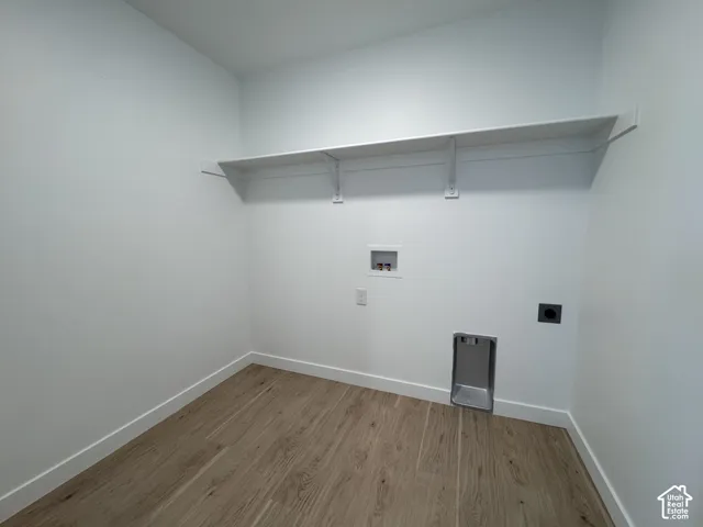 Wood-finish flooring, white walls, built-in shelving, and utility hookups