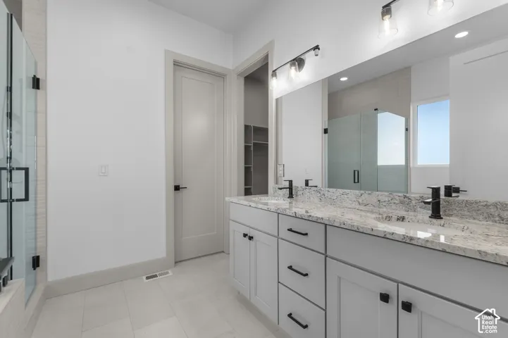 Dual vanity with granite countertop, matte black fixtures, and light grey cabinetry