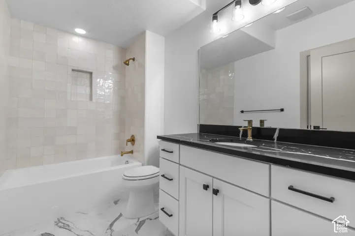 White subway tile shower surround with recessed niche, gold-finish fixtures, and a soaking tub