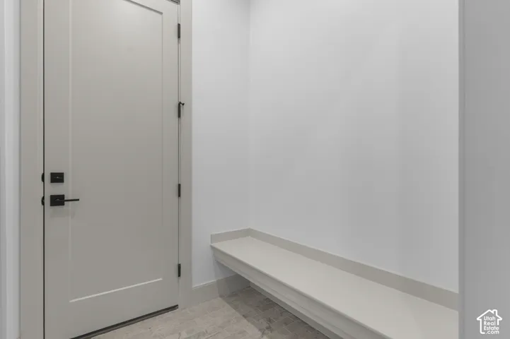 Built-in bench seating, contemporary door with matte black hardware, and tiled flooring