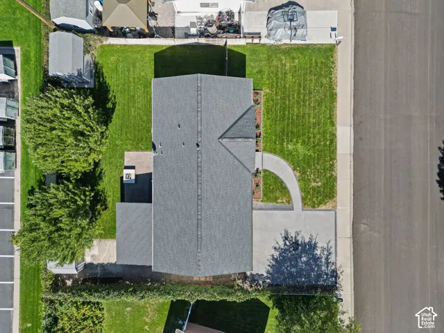 Asphalt shingle roof, concrete driveway, concrete sidewalk, curved concrete pathway, well-maintained lawn