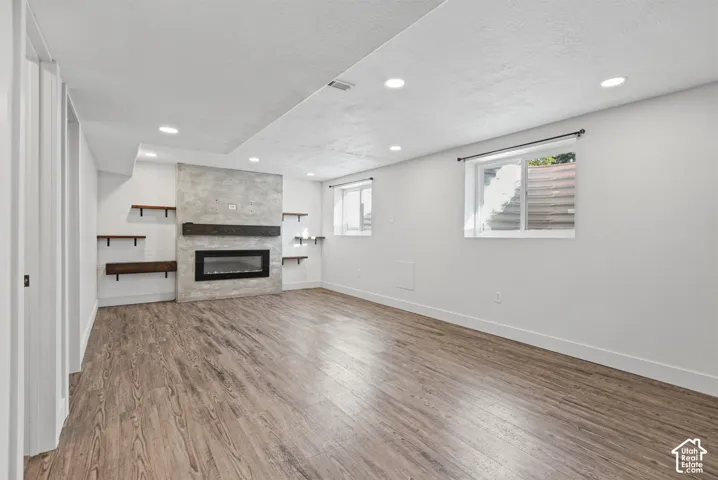 Recessed lighting, a built-in electric fireplace with a concrete-finish surround