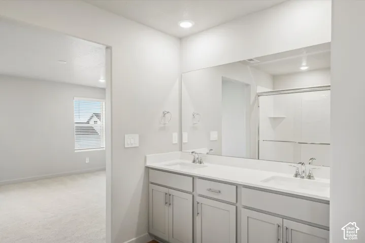 Dual vanity with undermount sinks, chrome fixtures, and light gray cabinetry