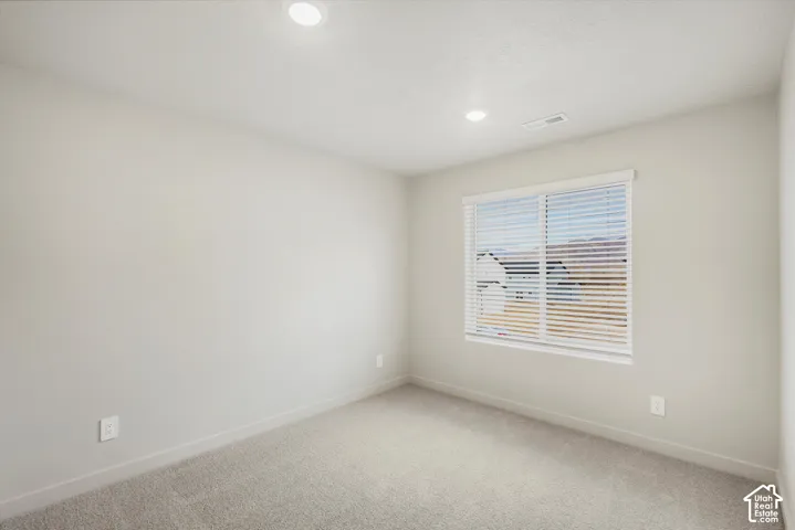 Recessed lighting, neutral wall paint, carpet flooring, window with blinds, and white trim