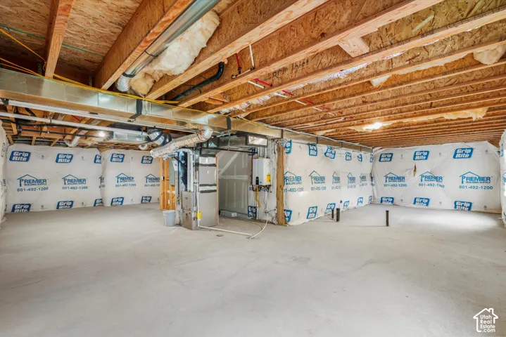 Unfinished basement with concrete flooring and exposed ceiling joists