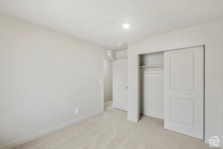 Wall-to-wall carpeting, recessed lighting, and a closet with sliding panel doors