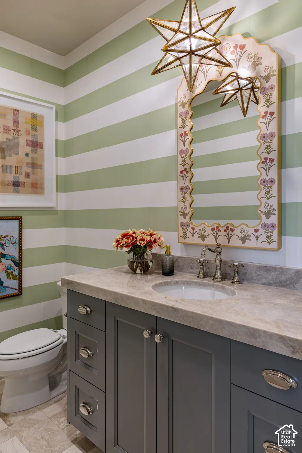 Vanity with a built-in sink, gray cabinetry, and a stone countertop