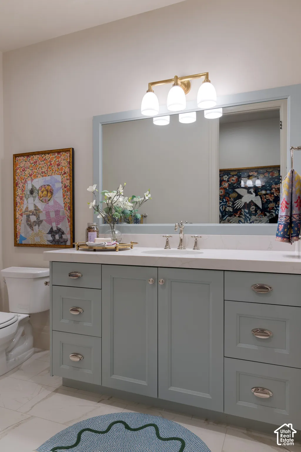 Vanity with light blue shaker-style cabinetry, a white countertop, and a built-in rectangular sink