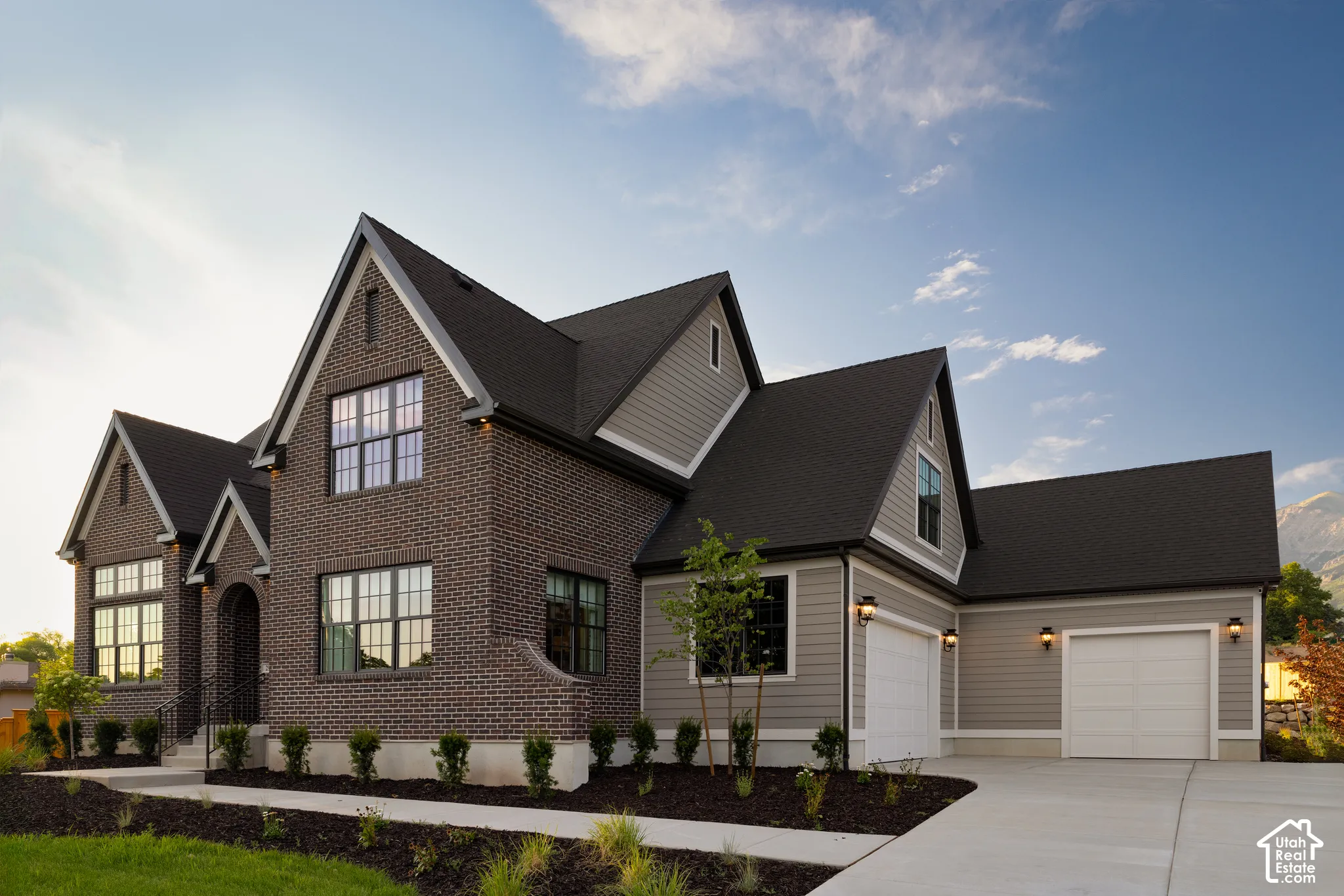 Brick and siding exterior with multiple gables and a dark roof