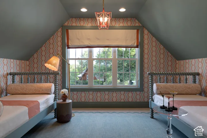 Attic space with sloped ceilings, a centered window, and recessed lighting