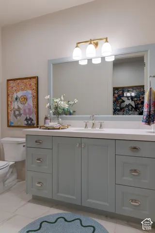 Vanity with light blue shaker-style cabinetry, a white countertop, and a built-in rectangular sink