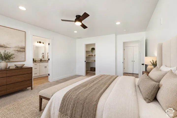 Recessed lighting, ceiling fan, carpet flooring, a built-in closet with shelving, and a bathroom with a dual vanity
