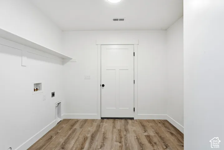 Wood-finish flooring, white walls, and a built-in shelf