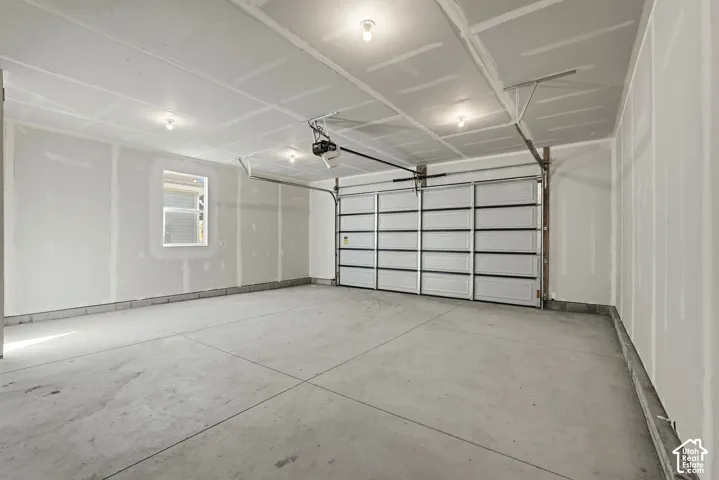 Concrete flooring, overhead lighting, sectioned garage door, built-in window