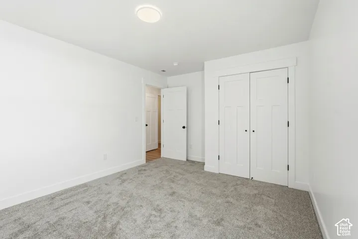 Wall-to-wall carpeting, bright white walls, and a recessed ceiling light fixture