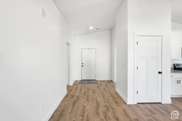 Wood-finish flooring throughout, bright white walls, and a recessed light fixture