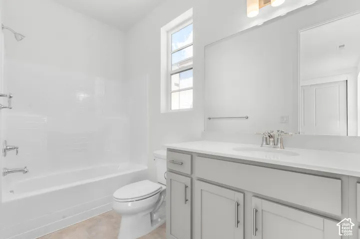 White subway tile bath surround, chrome fixtures, light gray vanity with white countertop, integrated sink, and large mirror