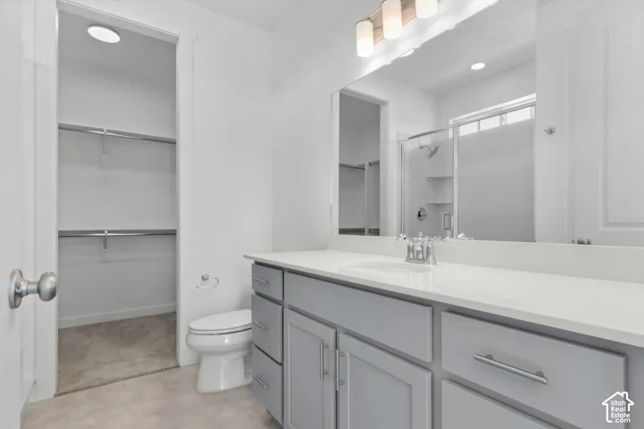 Vanity with a single basin, light gray cabinetry, and a light-colored countertop