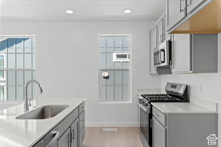 Kitchen featuring light-toned cabinetry, light countertops, wood-finish flooring, and recessed lighting