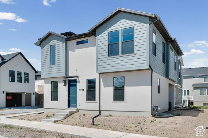 Contemporary exterior with contrasting siding, multiple large windows, and a prominent entry door