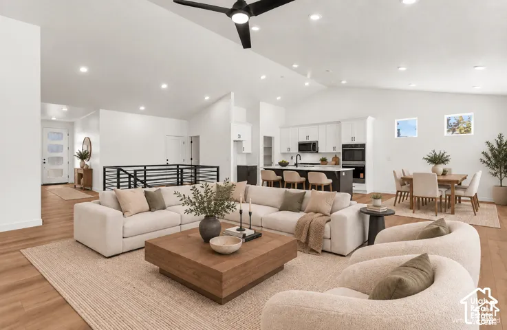 Vaulted ceilings, wood-finish flooring, recessed lighting, modern kitchen with built-in appliances, and a dining area with direct exterior light