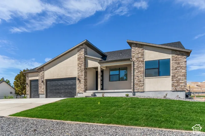 Contemporary exterior featuring stacked stone accents, stucco siding, and a dark asphalt shingle roof