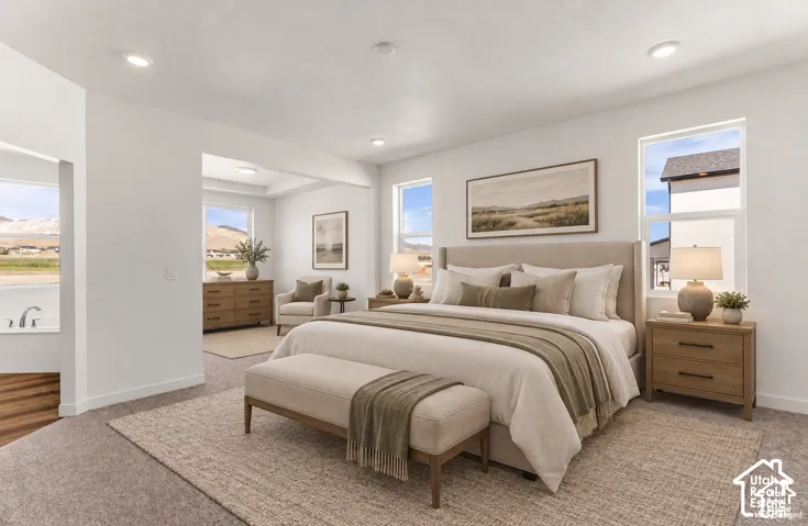 Recessed lighting, light-toned carpeting, wood-finish flooring, white walls, and a built-in tub