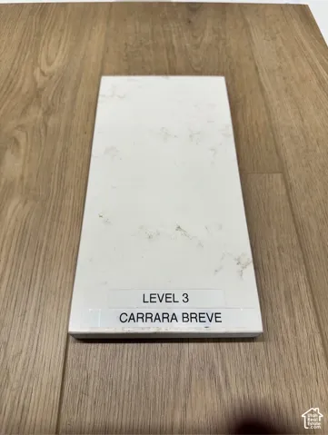 Engineered stone slab featuring white tones with tan veining, paired with light-toned wood-finish flooring